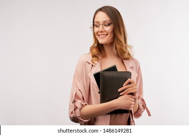 Young Attractive Business Woman, Wearing Fashionable Round Glasses And Trendy Pink Clothes, Holding Ipad And Business Planner In Her Hands, Looking Aside With Confident And Optimistic Expression.