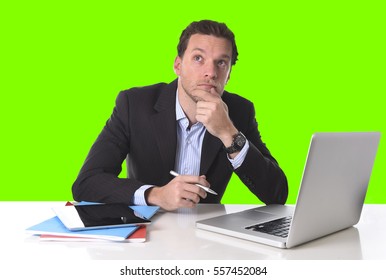 young attractive businessman working in stress at office desk computer laptop looking reflexive and doubtful, pensive and thoughtful isolated on green chroma key screen background - Powered by Shutterstock