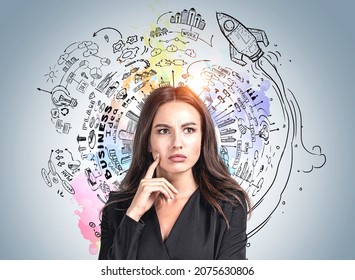 Young Attractive Businesswoman In Formal Suit Is Standing In Front Of Colourful Sketch With Brain, Goal, Bar And Pie Diagram In Background. Concept Of Imagination And Brainstorming For Creative Idea