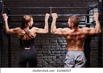 Young attractive caucasian crossfit man and woman working out in gym, rear view, couple - Powered by Shutterstock