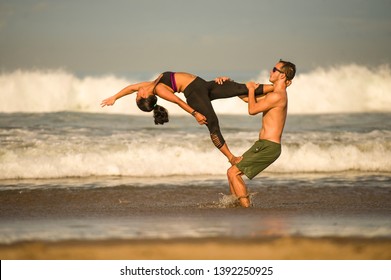young attractive and concentrated couple of acrobats practicing acro yoga balance and meditation exercise on beautiful beach under a blue sky in mind and body control and healthy lifestyle - Shutterstock ID 1392250925