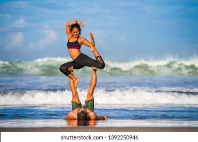 young attractive and concentrated couple of acrobats practicing acro yoga balance and meditation exercise on beautiful beach under a blue sky in mind and body control and healthy lifestyle
 - Powered by Shutterstock