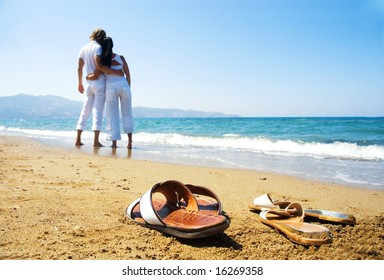 Young attractive couple at the beach (focused front view) - Powered by Shutterstock