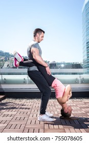 Young Attractive Couple Doing Advanced Double Dare Crunches While Standing On Rooftop Of The Building In Urban Area.