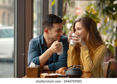 Young attractive couple on date in coffee shop having a conversation and enjoying the time spent with each other.  - Powered by Shutterstock