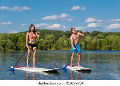 Young Attractive Couple On Stand Up Paddle Board In The Lake, SUP