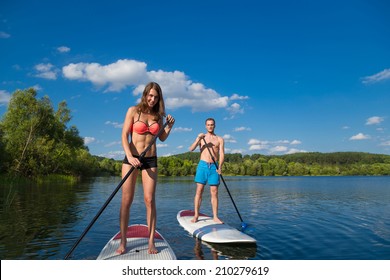 Young Attractive Couple On Stand Up Paddle Board In The Lake, SUP