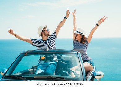 Young attractive couple posing in a convertible car, by the sea - Powered by Shutterstock