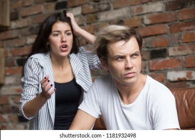 Young Attractive Couple Quarreling At Home. Girl Emotionally Screaming, Shouting At Boyfriend, Drama Queen Nagging, Angry Man Looking Away. Misunderstanding, Problems, Trouble In Relationship Concept