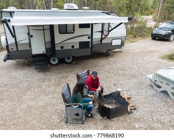 A Young Attractive Couple Relaxing At Their Camp Site While RV Camping