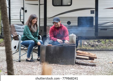 A Young Attractive Couple Relaxing At Their Camp Site While RV Camping