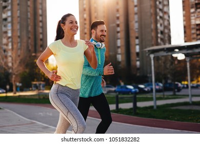 Young Attractive Couple Running Outside On Sunny Day