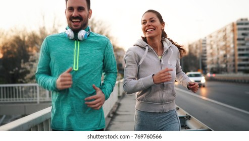 Young Attractive Couple Running Outside On Sunny Day