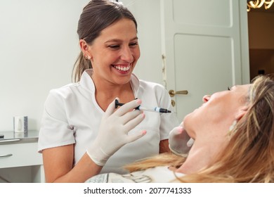 Young And Attractive Dentist Performing Adhesive Cement Treatment On A Beautiful Patient. Concept Dental Care, Health Care.