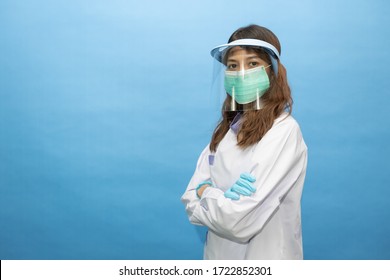 Young Attractive Dentist Wearing Surgical Mask And Face Shield. The Written On Her Gown Is He Name In Thai Alphabets