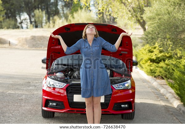 young\
attractive desperate and confused woman stranded on roadside\
looking worried to broken car engine failure or crash accident in\
automobile road assistance and insurance\
concept