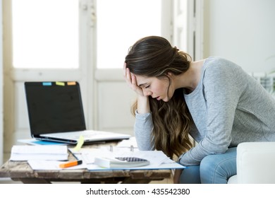 Young Attractive And Desperate Woman Suffering Stress Doing Domestic Accounting Paperwork Bills And Invoices Worried And Stressed At Home Sofa Couch With Laptop Computer And Bank Receipts