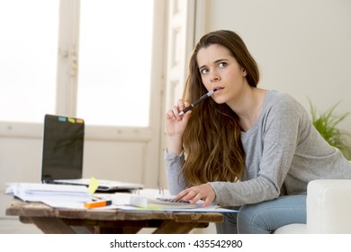 Young Attractive And Desperate Woman Suffering Stress Doing Domestic Accounting Paperwork Bills And Invoices Worried And Stressed At Home Sofa Couch With Laptop Computer And Bank Receipts