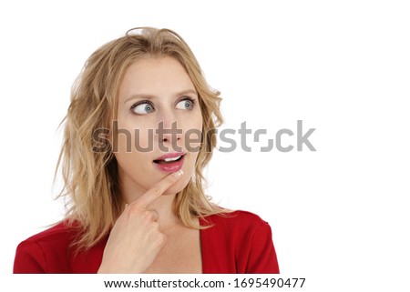 
young and attractive expressive blonde woman with blue eyes and wearing red t-shirt thinking on studio isolated white background