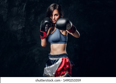 Young attractive female boxer with long hair and boxing gloves is ready to fight. - Powered by Shutterstock