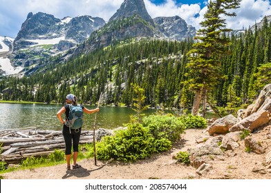 Young attractive female enjoying stunning view at lake Odessa with notchtop peak in rocky mountain national park colorado