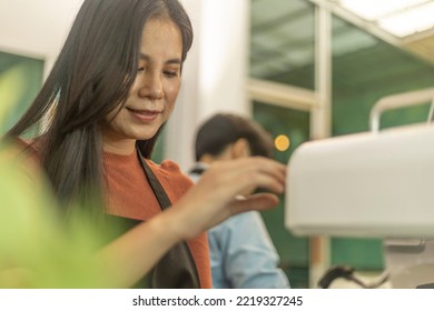 Young Attractive Female Owner Works With Her LGBT Partner To Run A Coffee Shop Business. A Lady With Apron Prepares Fresh Coffee With Machine. 