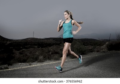 young attractive and fit sport woman running outdoors on asphalt road in mountain landscape on evening with harsh light in fitness workout training shot in motion blurred advertising style - Powered by Shutterstock