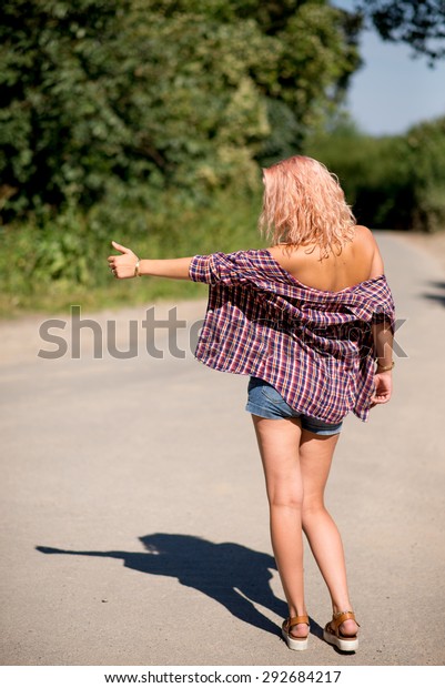 Young attractive girl in bikini with small pants\
hitchhiking back shot