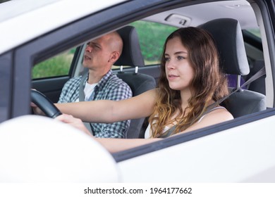 Young Attractive Girl Driving Car With Man In Passenger Seat During Trip, Side View