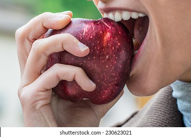 a young attractive girl eats an apple