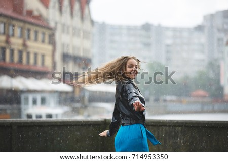 Young attractive girl is enjoying the summer rain