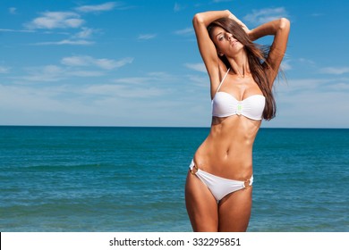 Young attractive girl enjoys hot summer day at the beach.
