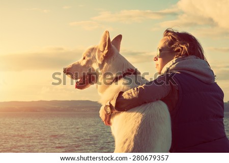 Young attractive girl with her pet dog at a beach, colorised image