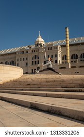 A Young Attractive Girl Makes A Dance Jumps Leap Along The Staircase Leading To The 