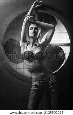 a young attractive girl poses in the background in an industrial style