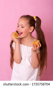 Young attractive girl posing at studio with lemon. Vitamin CPortrait of pretty little girl holding slices of orange