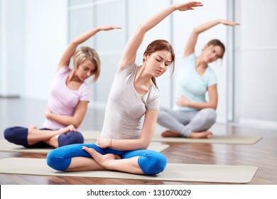 Young attractive girls do yoga - Powered by Shutterstock