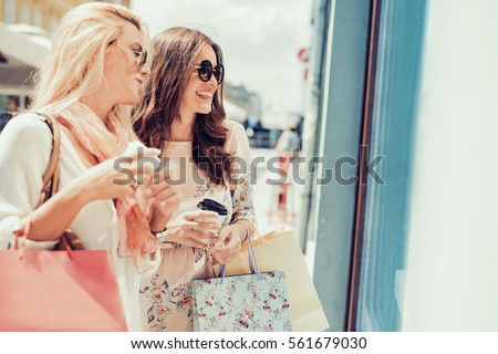 Young attractive girls with shopping bags in the city.
