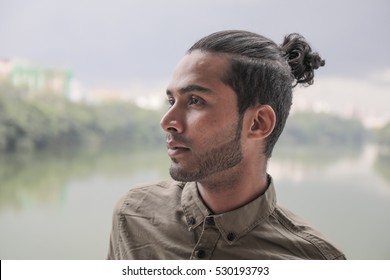 Young And Attractive Guy With A Male Hair Bun On Top Of His Head