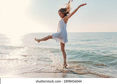 Young Attractive Happy Woman Dancing Turning Around By Sea Beach Sunny Summer Fashion Style In White Dress Vacation