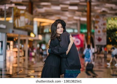 A Young And Attractive Indian Asian Woman Is Hugging Her Boyfriend In A Futuristic Airport During The Day. She Looks Sad At The Prospect Of Missing Him As He Goes Out Of Country. 