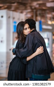 A Young And Attractive Indian Asian Woman Is Hugging Her Boyfriend In A Futuristic Airport During The Day. She Looks Sad At The Prospect Of Missing Him As He Goes Out Of Country. 