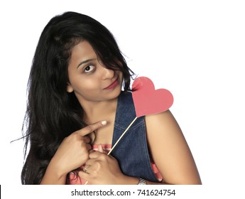 A Young Attractive Indian Girl  Hand Holding Heart Photo Booth Prop.