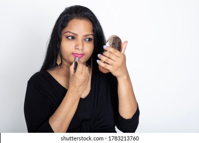 Young Attractive Indian Woman Applying Lipstick Looking Into Mirror