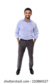 Young Attractive Latin Or Spanish Business Man Standing Full Body In Corporate Portrait Isolated On White Background Smiling With Hands In Pockets Wearing Shirt And Suit Trousers