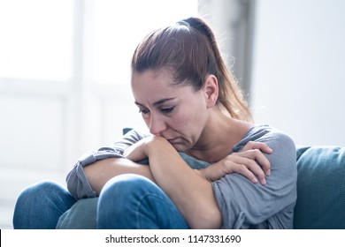 Young attractive latin woman lying at home living room couch feeling sad tired and worried suffering depression in mental health, problems and broken heart concept.