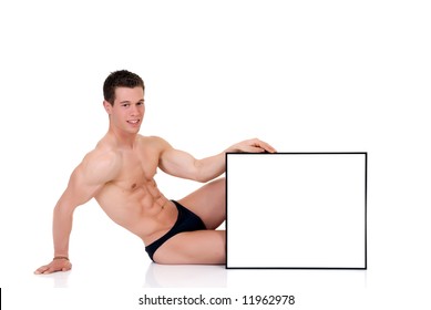 Young attractive male body builder with advertising board. Studio shot, white background.