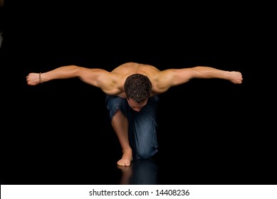 Young Attractive Male Body Builder, Demonstrating Artistic Pose. Studio Shot, Black Background.