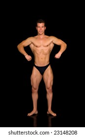 Young attractive male body builder, demonstrating contest pose. Studio shot, black background.
