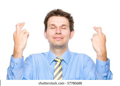 young attractive male holds his fingers crossed and eyes closed, wishful thinking, studio shoot isolated on white background